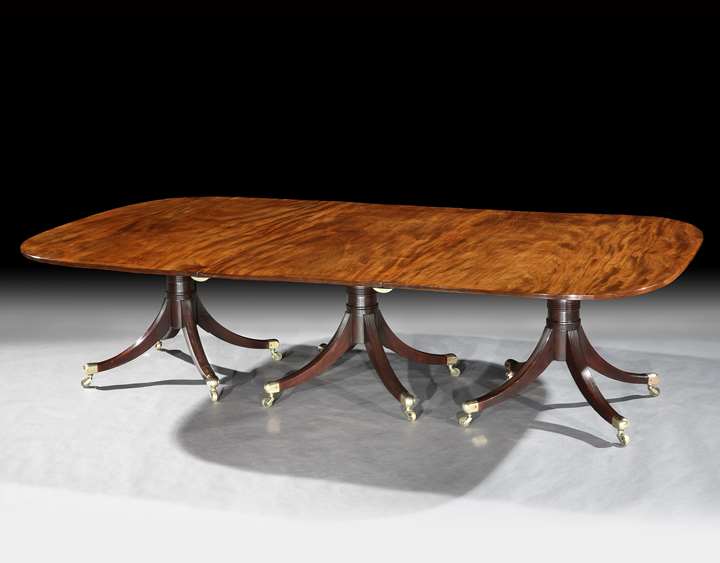 A GEORGE III MAHOGANY THREE PILLAR DINING TABLE